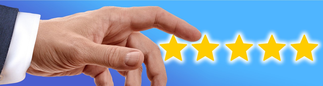 Un dito di una mano indica le cinque stelle gialle delle recensioni.